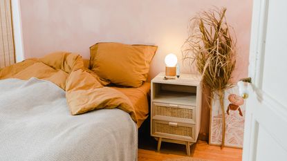 A small bedroom with a bed, bedside table and table lamp