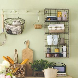 Green-painted kitchen with black wire shelving