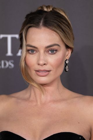 Margot Robbie is seen with a single-strand hairstyle and bun at the 2024 EE BAFTA Film Awards at The Royal Festival Hall on February 18, 2024 in London, England.