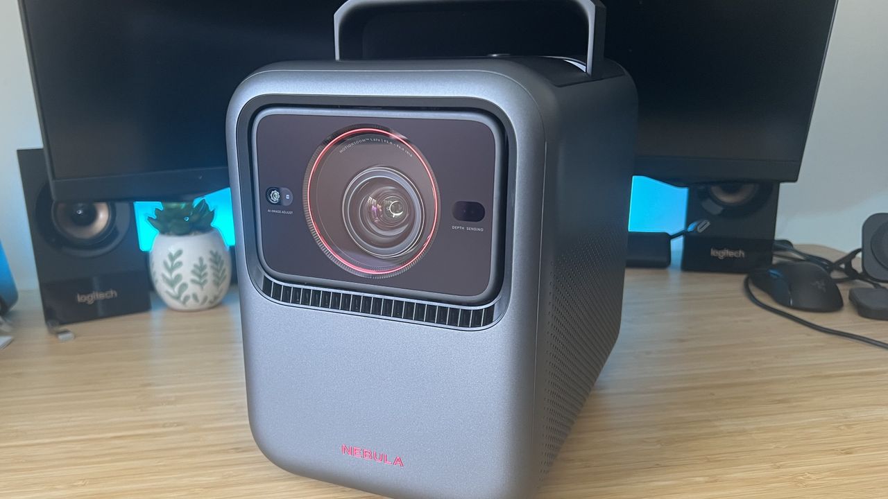 Anker Nebula X1 projector on a wooden desk with blue backlighting