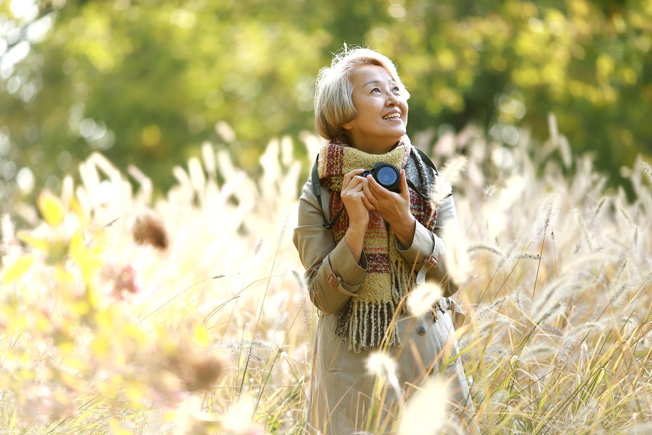 A woman holding a camera in a field