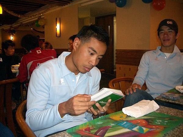 Daniel Lee studies his English slang while Derek Wong looks on.