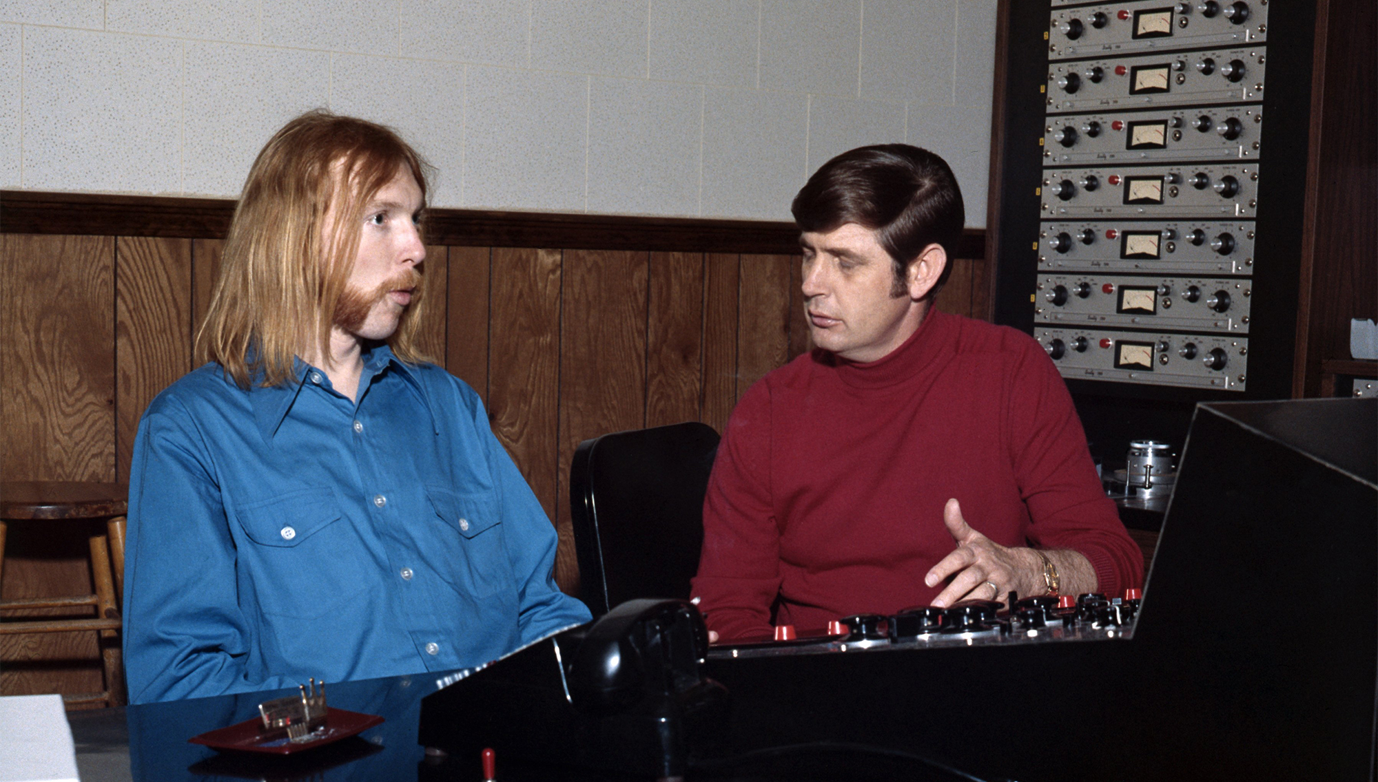 MUSCLE SHOALS, AL - 1968: Songwriter and producer Rick Hall (right) and session guitarist Duane Allman (left) at the mixing board at FAME Studios in 1968 in Muscle Shoals, Alabama. )