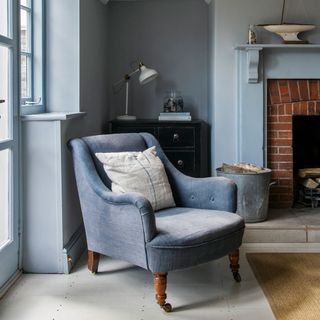 Blue living room with blue armchair and white table lamp in alcove
