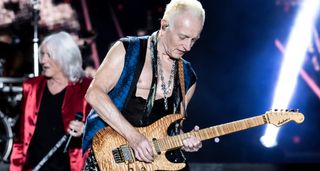 Phil Collen plays his Jackson PC1 onstage with Joe Elliott in the background