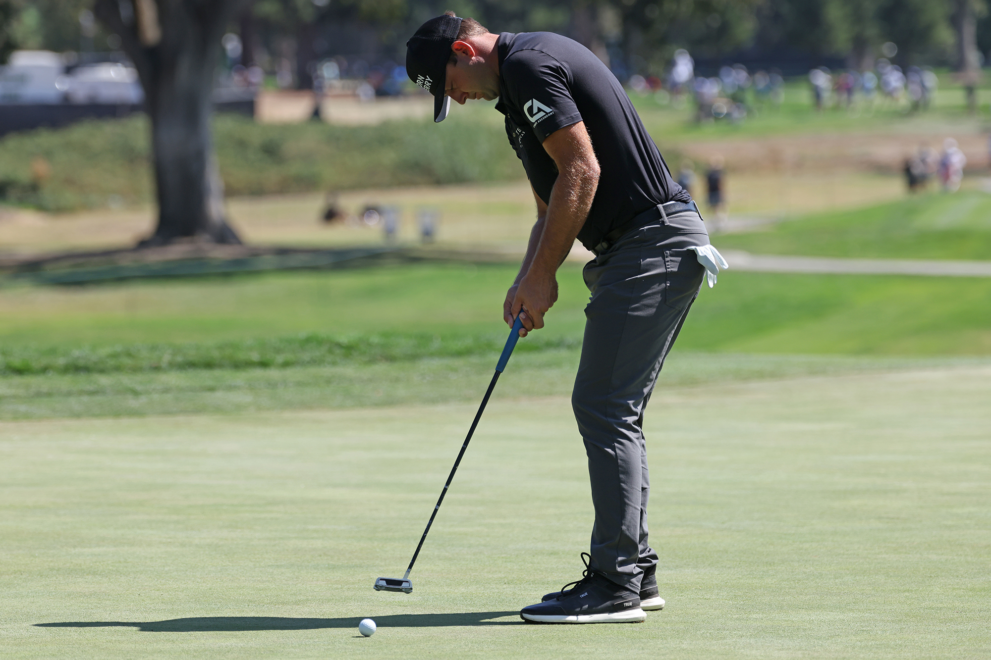 Taylor Montgomery hitting a putt on the green