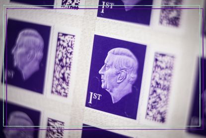 A close up of a purple first class stamp with King Charles' profile on it