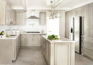 Kitchen with neutral cabinets and island and neutral floor and white tile backsplash