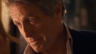 Hugh Grant leans into Renee Zellweger with a charming smile in Bridget Jones: Mad About The Boy.