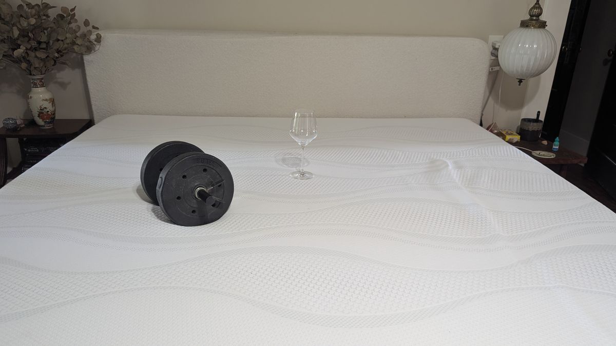 Dumbbells and wine glass placed on Sleep Number i8 smart mattress showing motion isolation