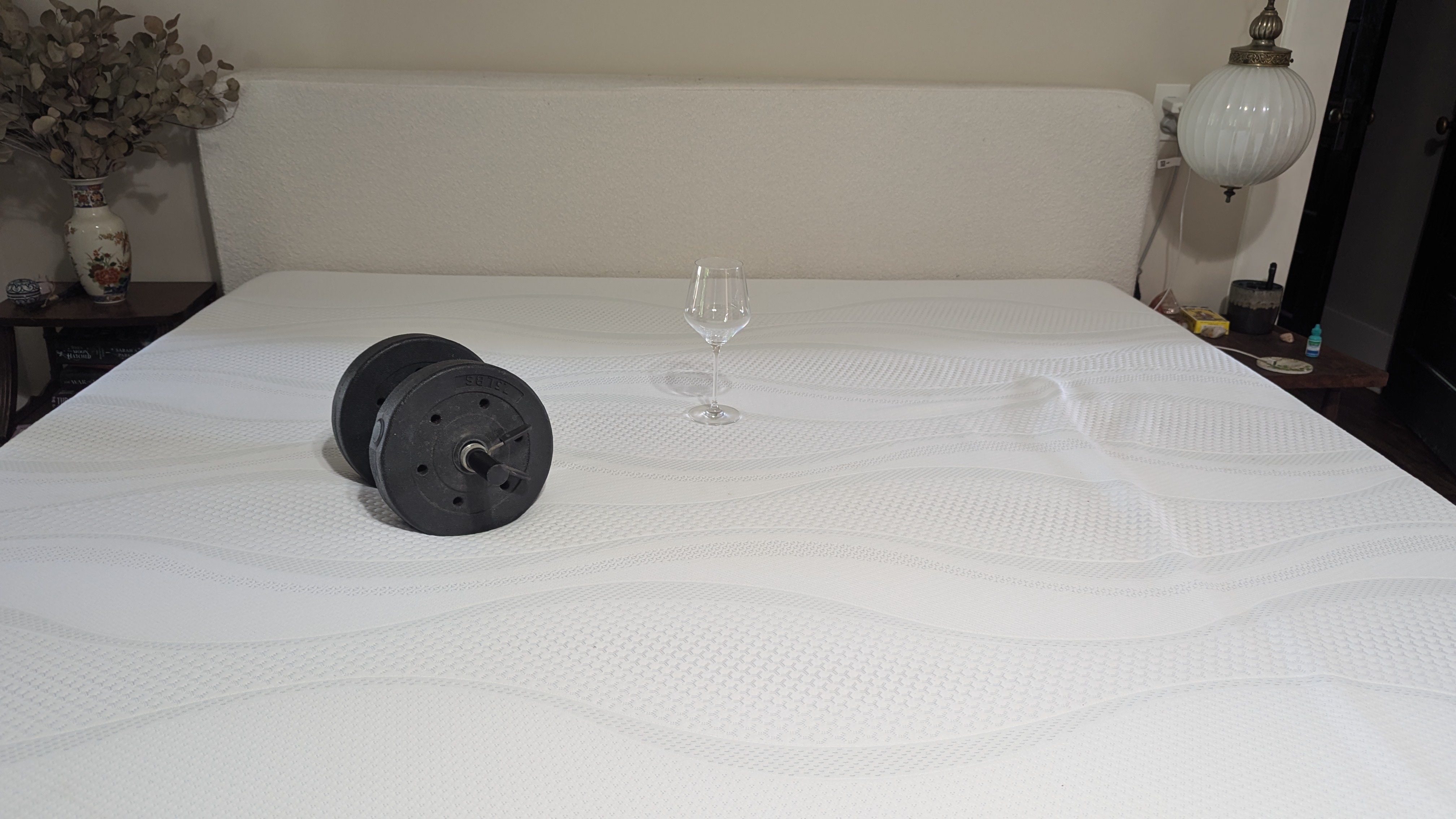 Dumbbells and wine glass placed on Sleep Number i8 smart mattress showing motion isolation