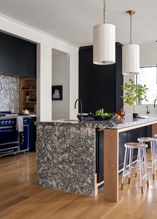 Kitchen island with waterfall countertop and clear plastic bar stools