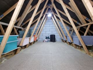 Boarded out loft with a frame and storage showing