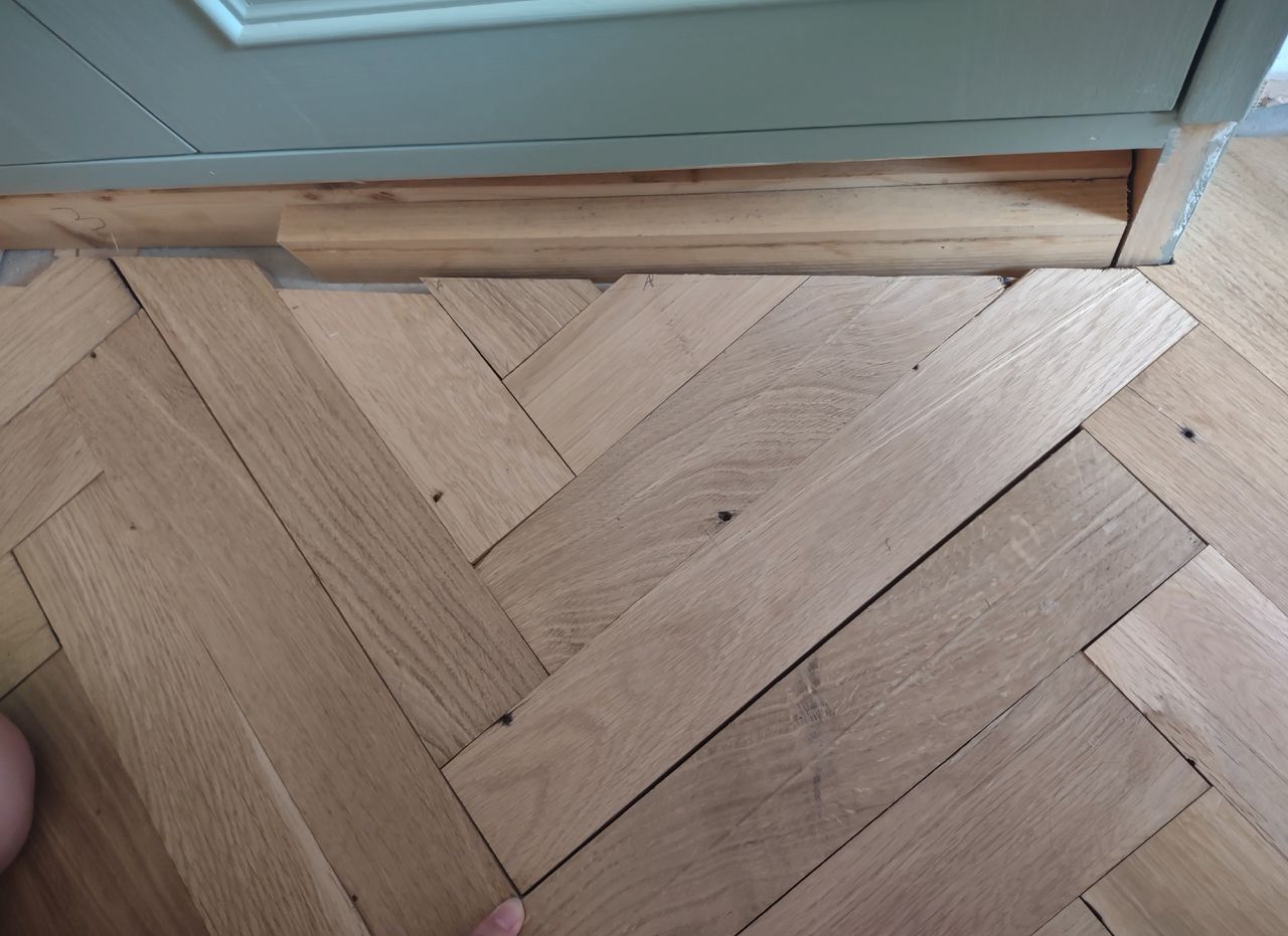 Herringbone flooring being positioned into place
