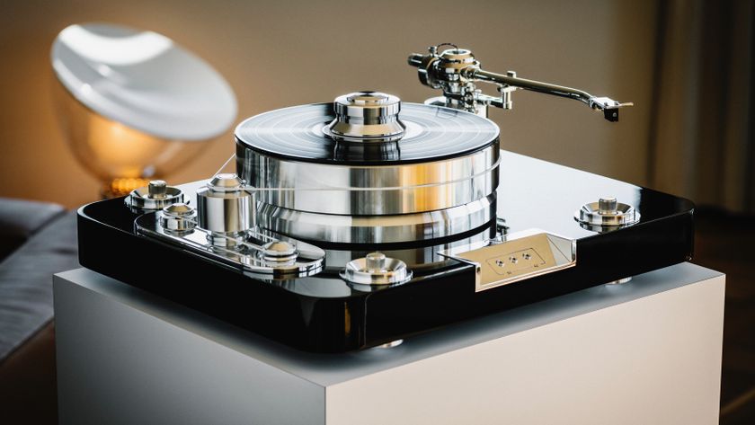 A Pro-Ject Signature 12.2 record player on a plinth with a lamp in the background.