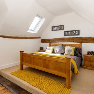 attic bedroom with frame on wall and couch on bed