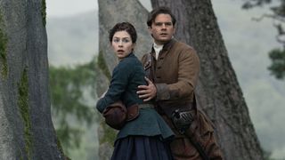 Julia and Henry looking scared, as Henry holds her from behind. 