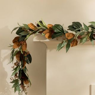 faux garland with green and orange leaves on mantel