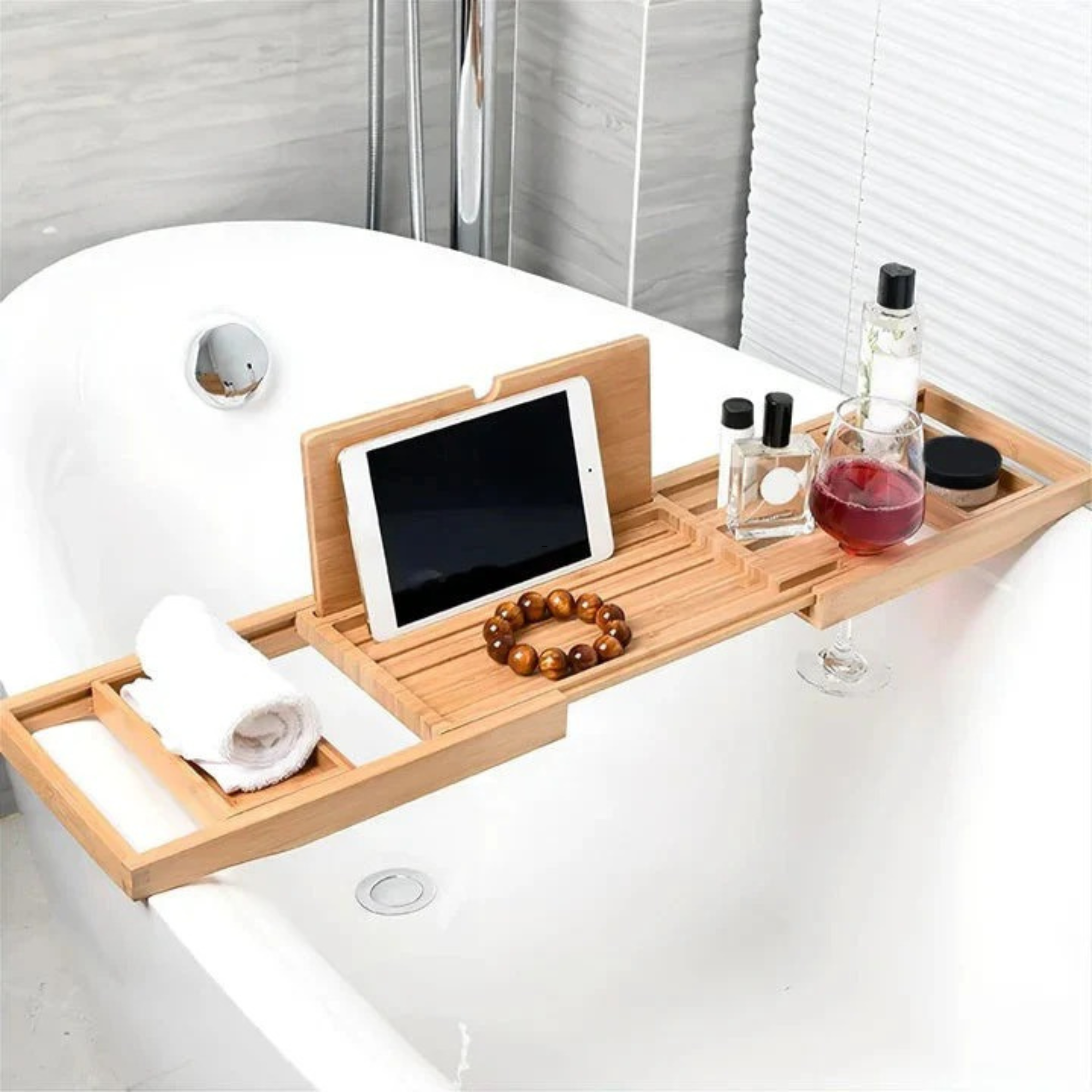 a bamboo bath caddy with an iPad, a glass of wine, and a small towel