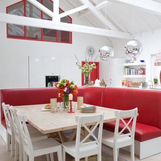 Large white kitchen with red seats