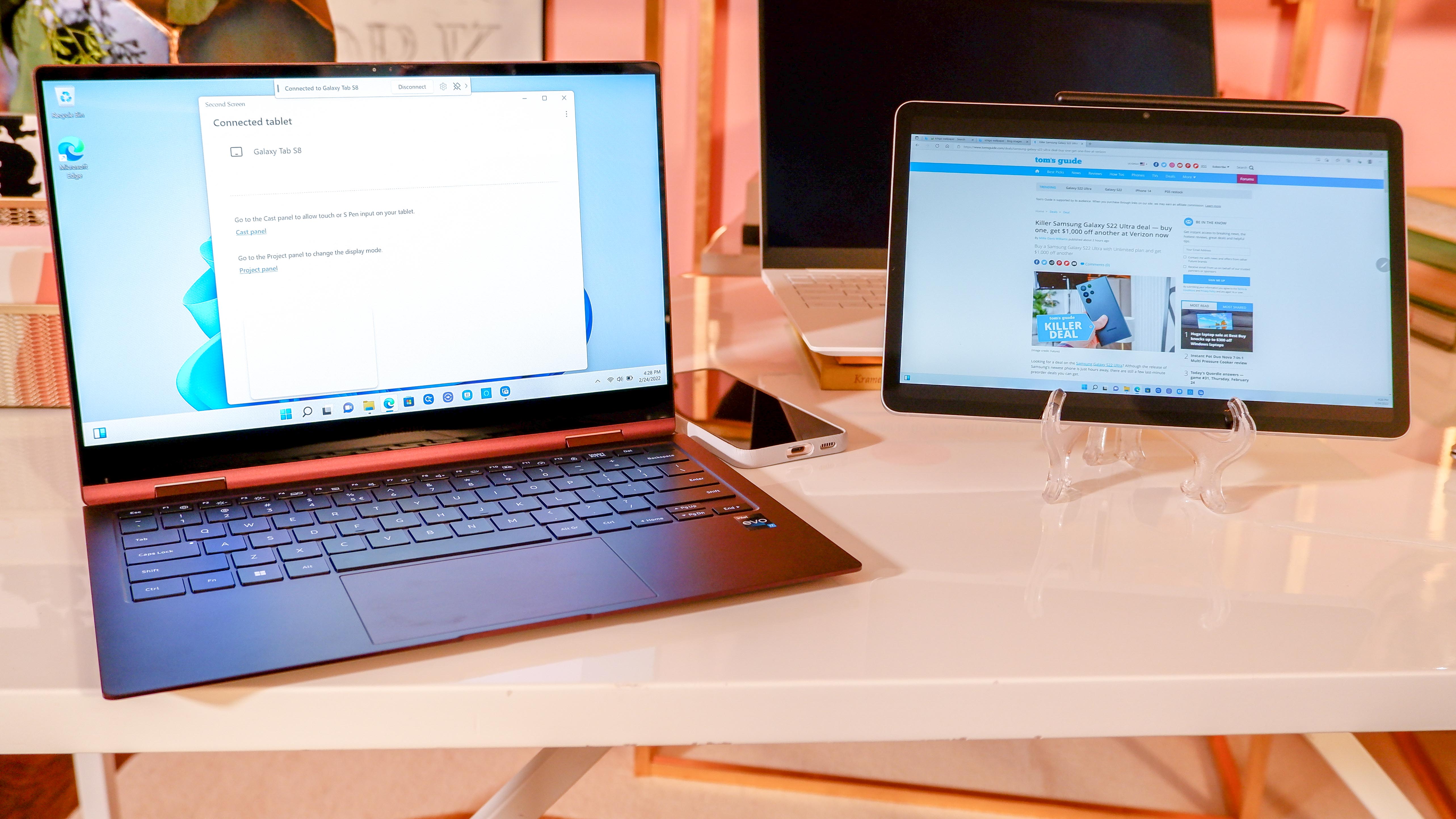 Samsung Galaxy Book2 Pro 360 open on table next to Samsung tablet