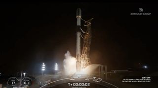 a black and white spacex rocket launches into a night sky