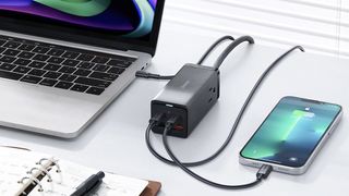 PowerCombo charger on desk charging a laptop and iPhone