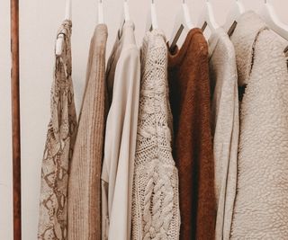 Neutral colored clothes hanging on a rail