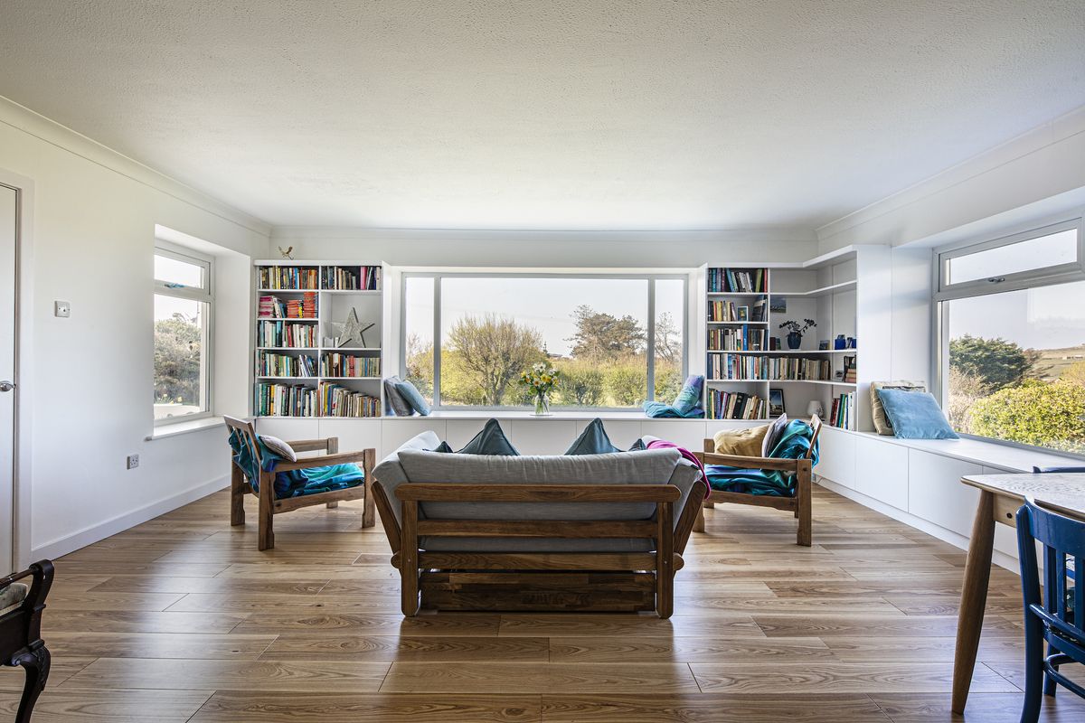 living room in retrofitted house with picture window and bookcase
