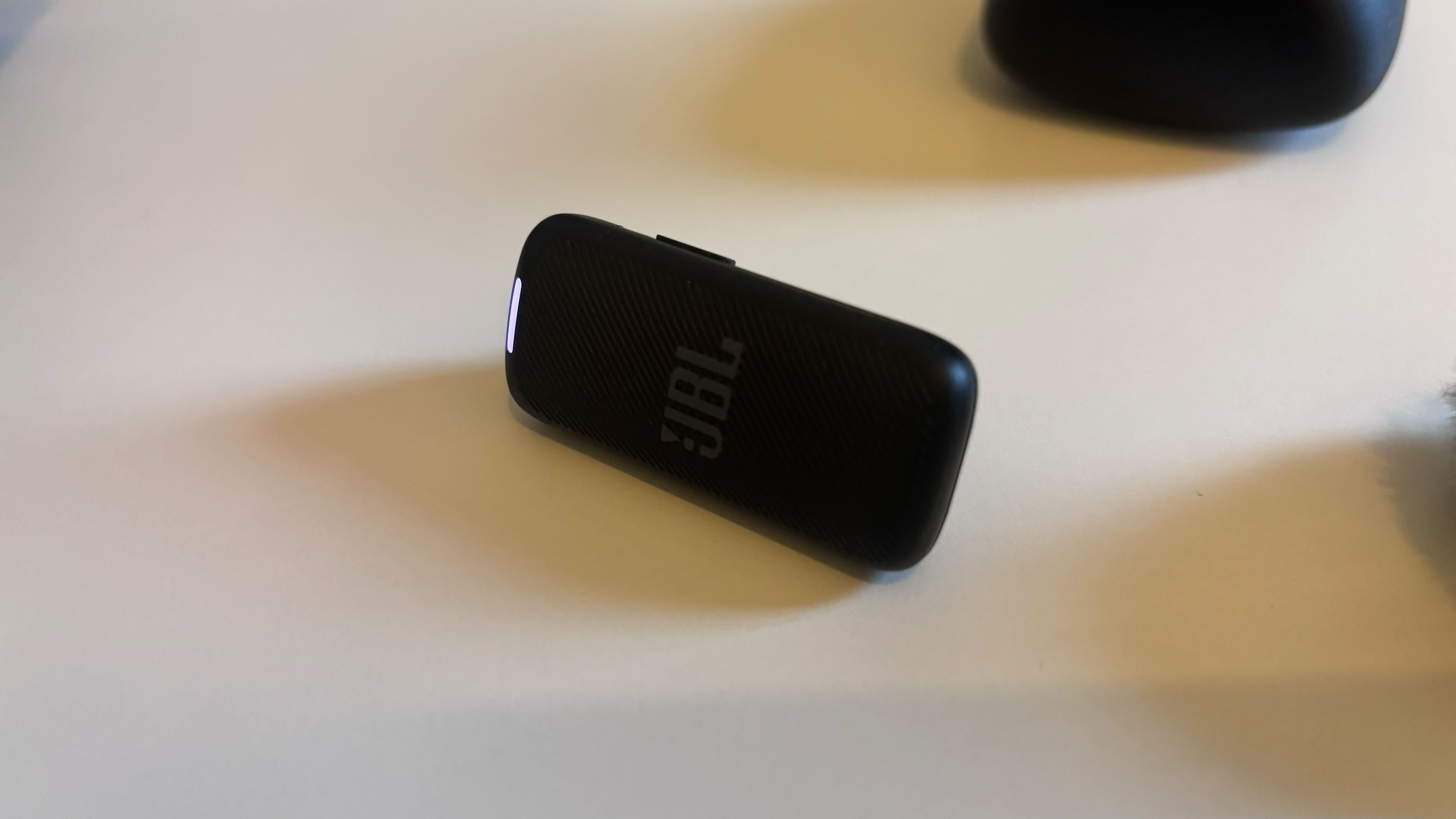 The JBL Quantum Stream Wireless mic on a flat white surface.