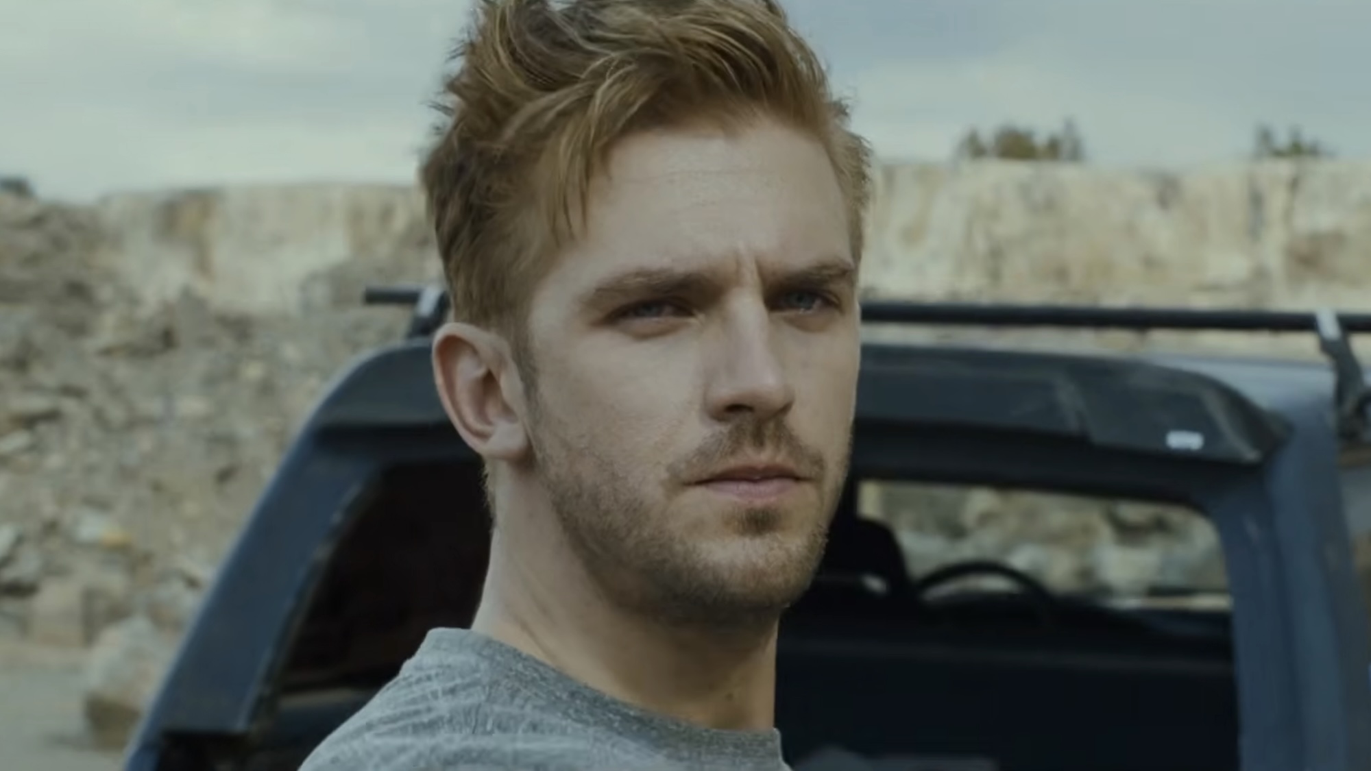 David Collins standing behind vehicle buying a weapon in The Guest (2014)
