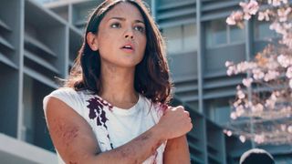 Eiza Gonzalez in a bloody T-shirt holding her arm in Ambulance movie