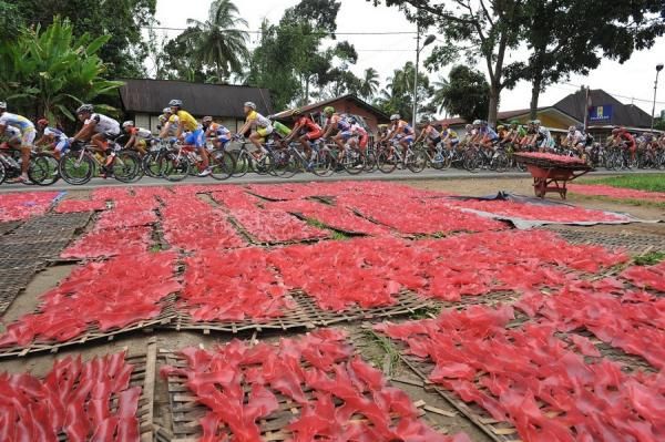 Tour de Singkarak 2012 riders through the industry that produces small red potato chips. Payakumbuh, West Sumatra is famous for its agricultural production and farming.
