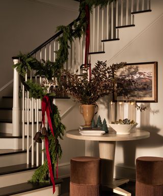 Entryways decorated for the holidays with a garland down the stairs