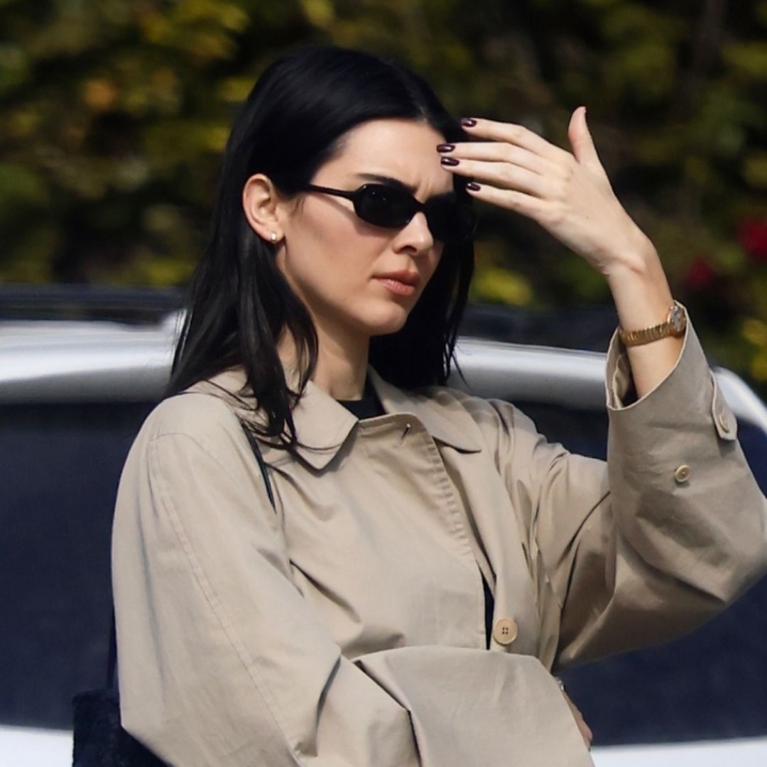 Kendall Jenner embraces high vamp ballet flats, white pants, and a woven bag