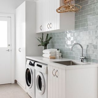 Laundry room with white cabinets