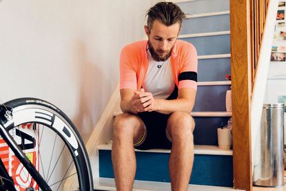 tired cyclist sitting on stairs