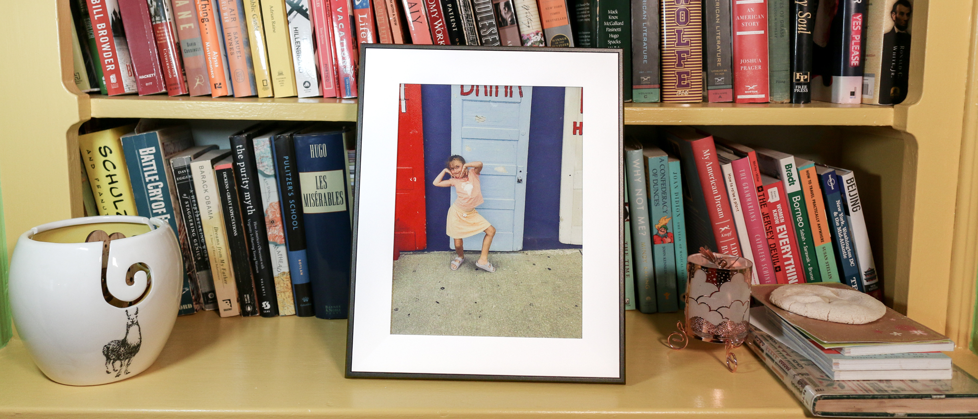 Aura Ink digital photo frame on a book shelf