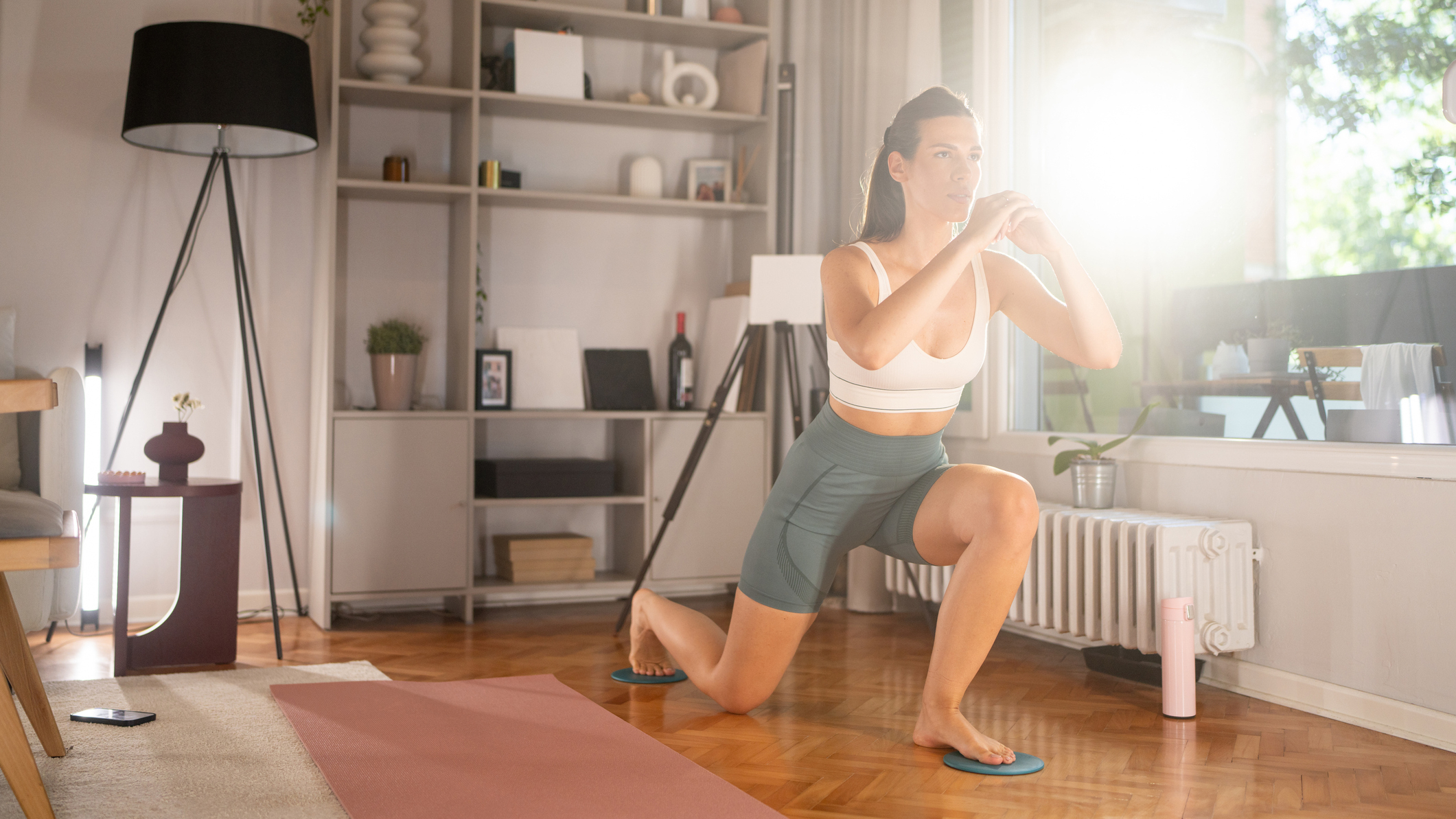 Woman exercising using sliders at home