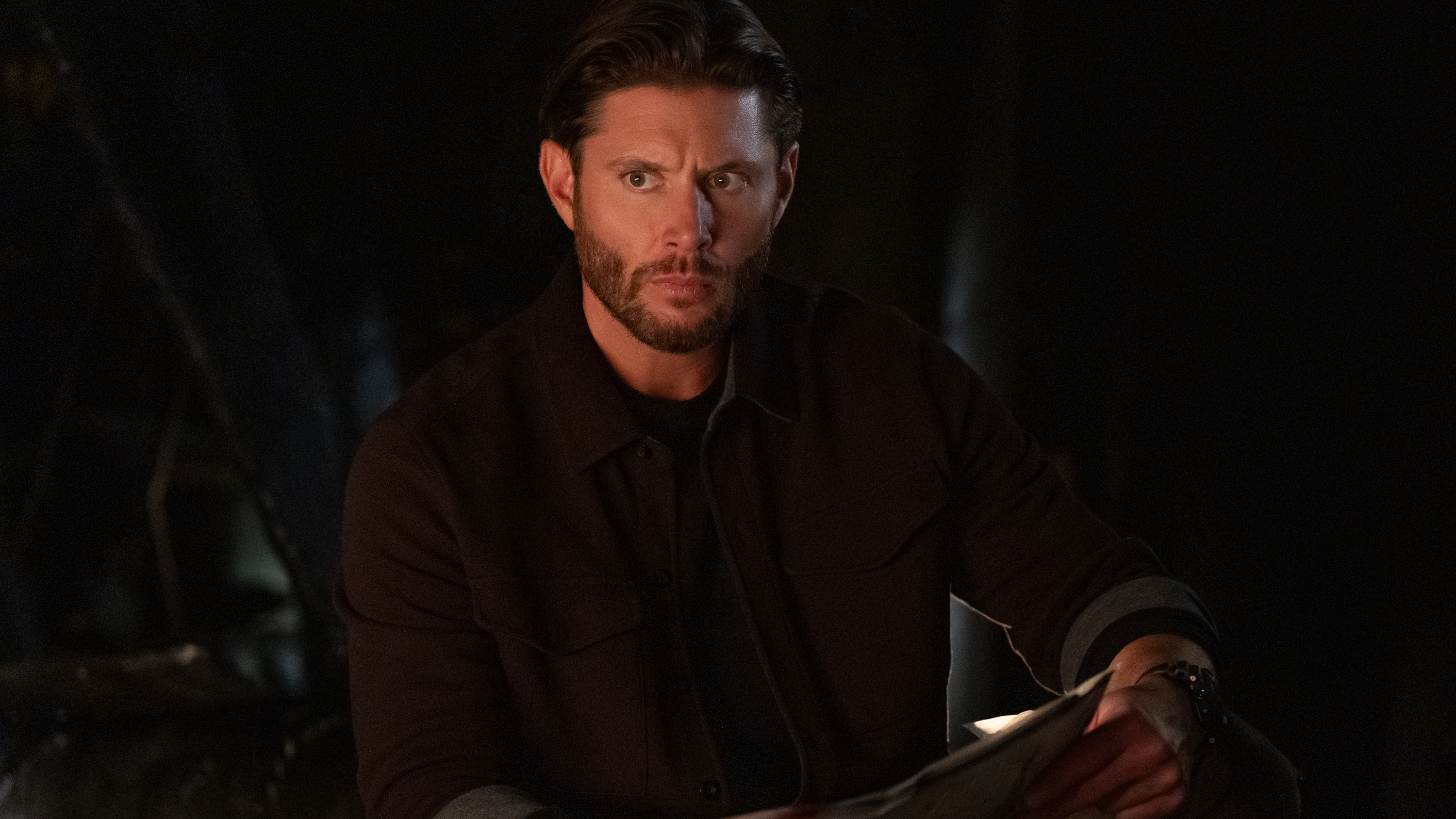 Mark (Jensen Ackles) holding documents at night in a scene from Prime Video's "Countdown"
