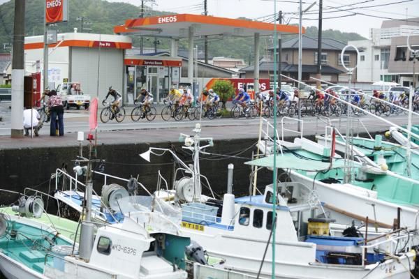 The peloton passes a small fishing port on the final day of racing.