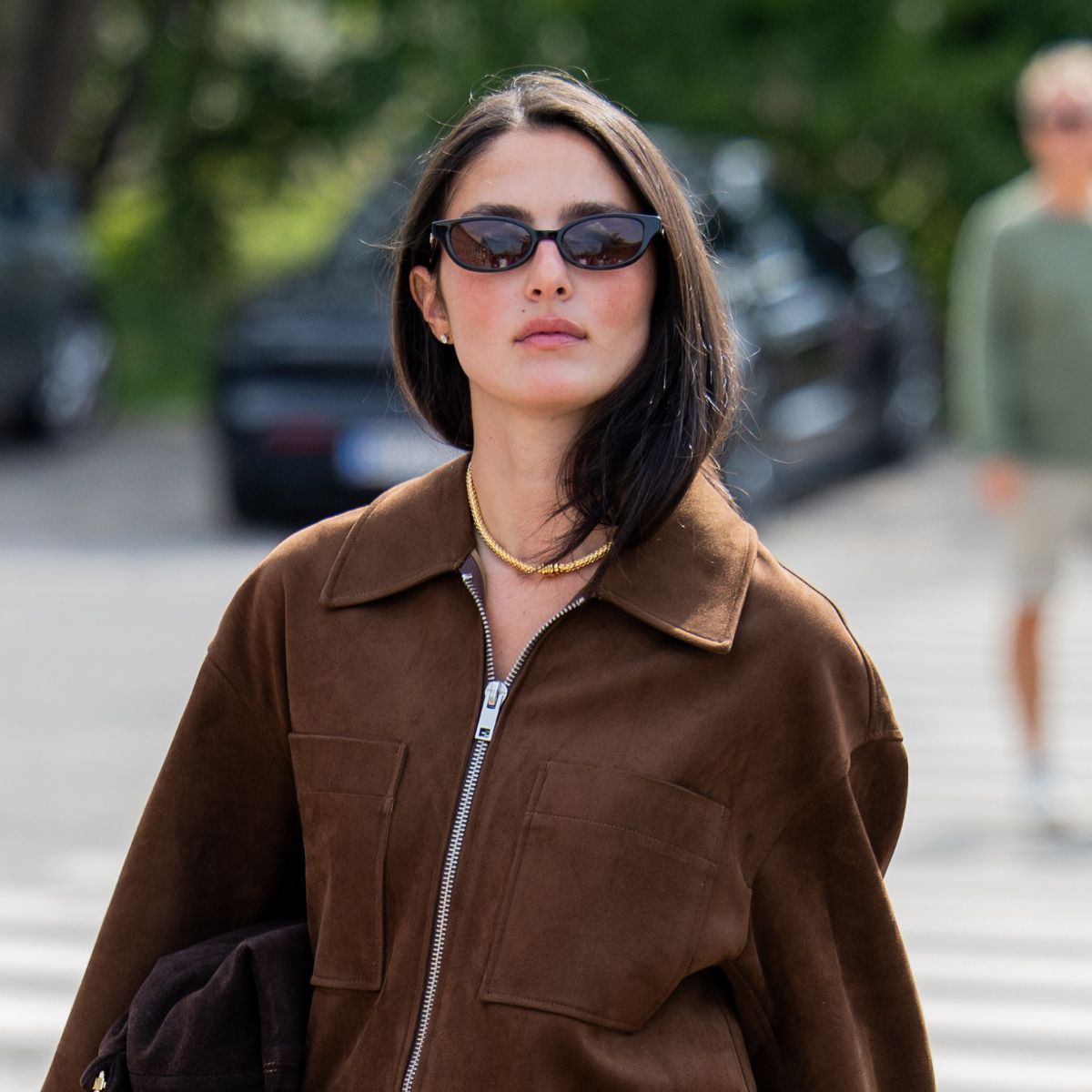brunette woman wearing suede jacket with blushed cheeks