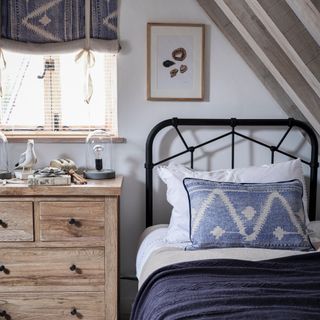 how to make a guest room look more expensive, guest bedroom, single bed with matching blind and cushion, black iron bed with chest of drawers, nautical elements