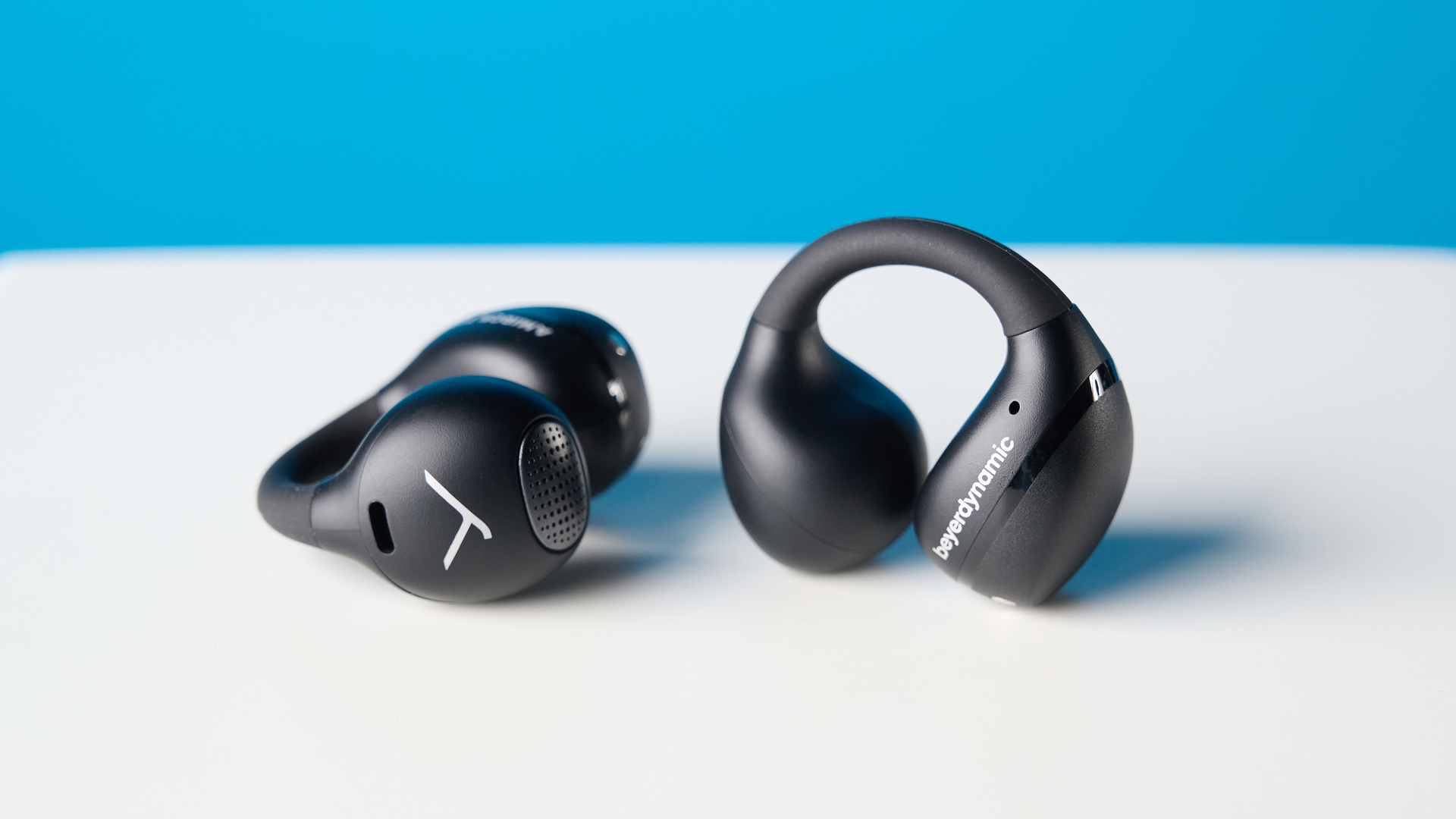 Beyerdynamic Amiron ZERO open-earbuds photographed on a blue background