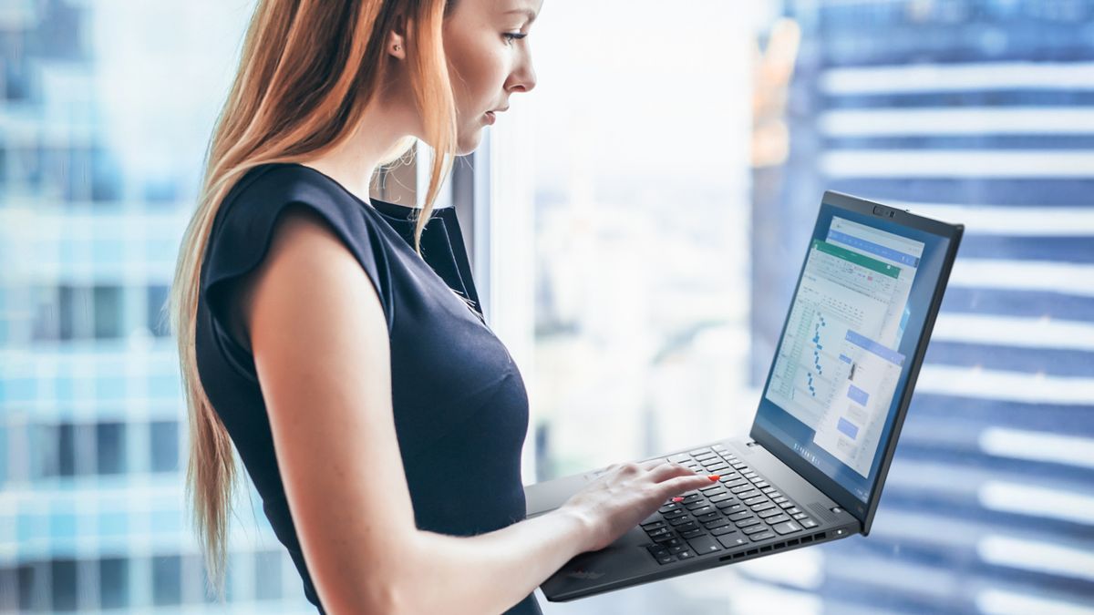 Woman using a Lenovo laptop while standing up in an office