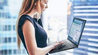 Woman using a Lenovo laptop while standing up in an office