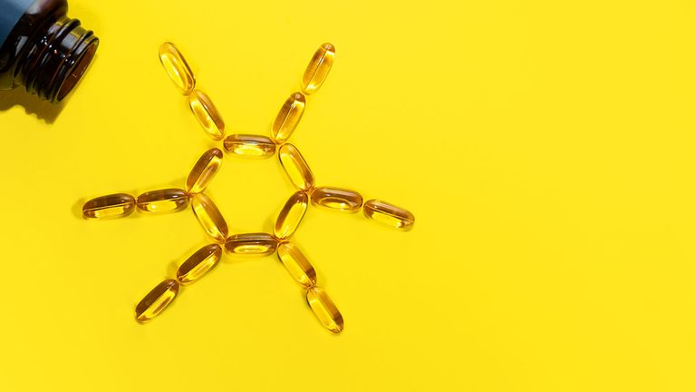 Vitamin D supplements arranged in a sunshine icon