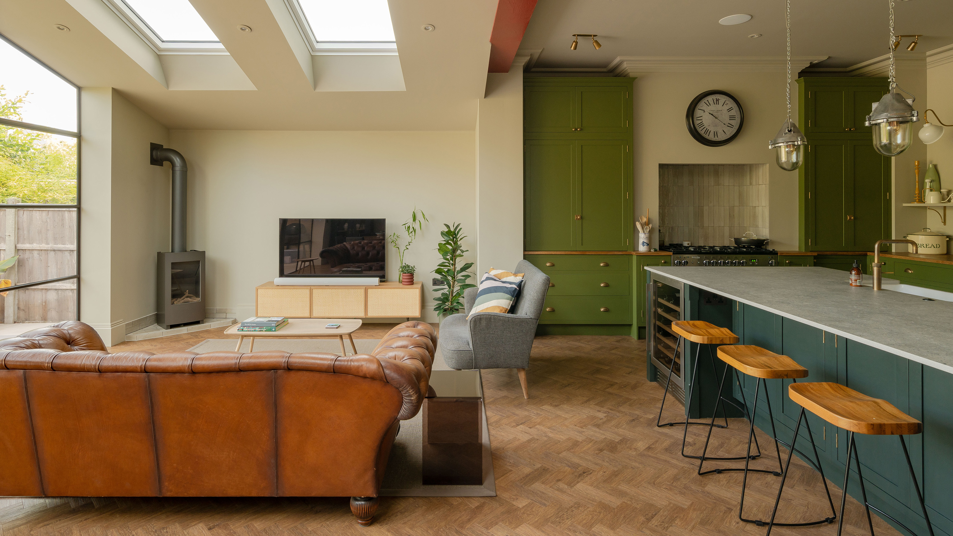 wooden parquet floor in open plan extended kitchen with zoned living room with brown and grey sofas