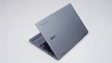 A silver laptop against a white background, its lid halfway open with the brand logo facing the camera.