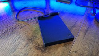 Seagate Portable HDD on a gaming desk under blue lighting